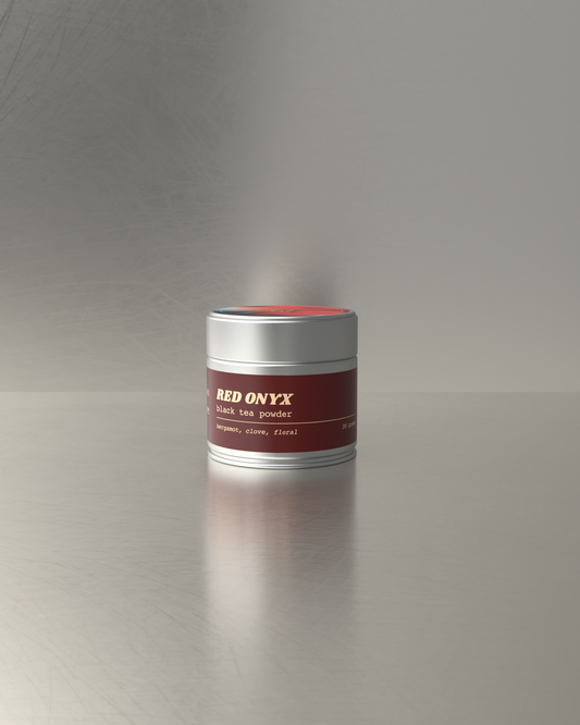 Teawerx Red Onyx black tea powder on a reflective surface with a gray background