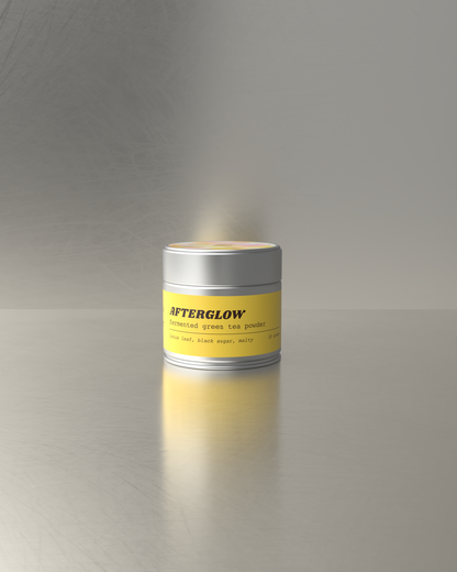 Teawerx fermented green tea labeled 'AFTERGLOW' on a reflective surface with a gray background