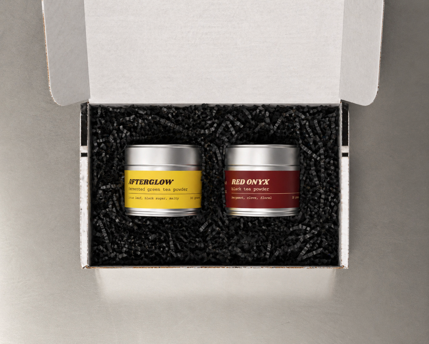 Teawerx Discovery Gift Box featuring Afterglow fermented tea powder and Red Onyx black tea powder in premium metal tins with black gift box filling.